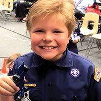 excited cub scout with pinewood derby car
